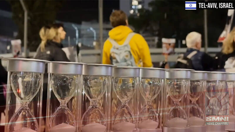 Relatives place 129 hour glasses for Hamas hostages during Israeli rally